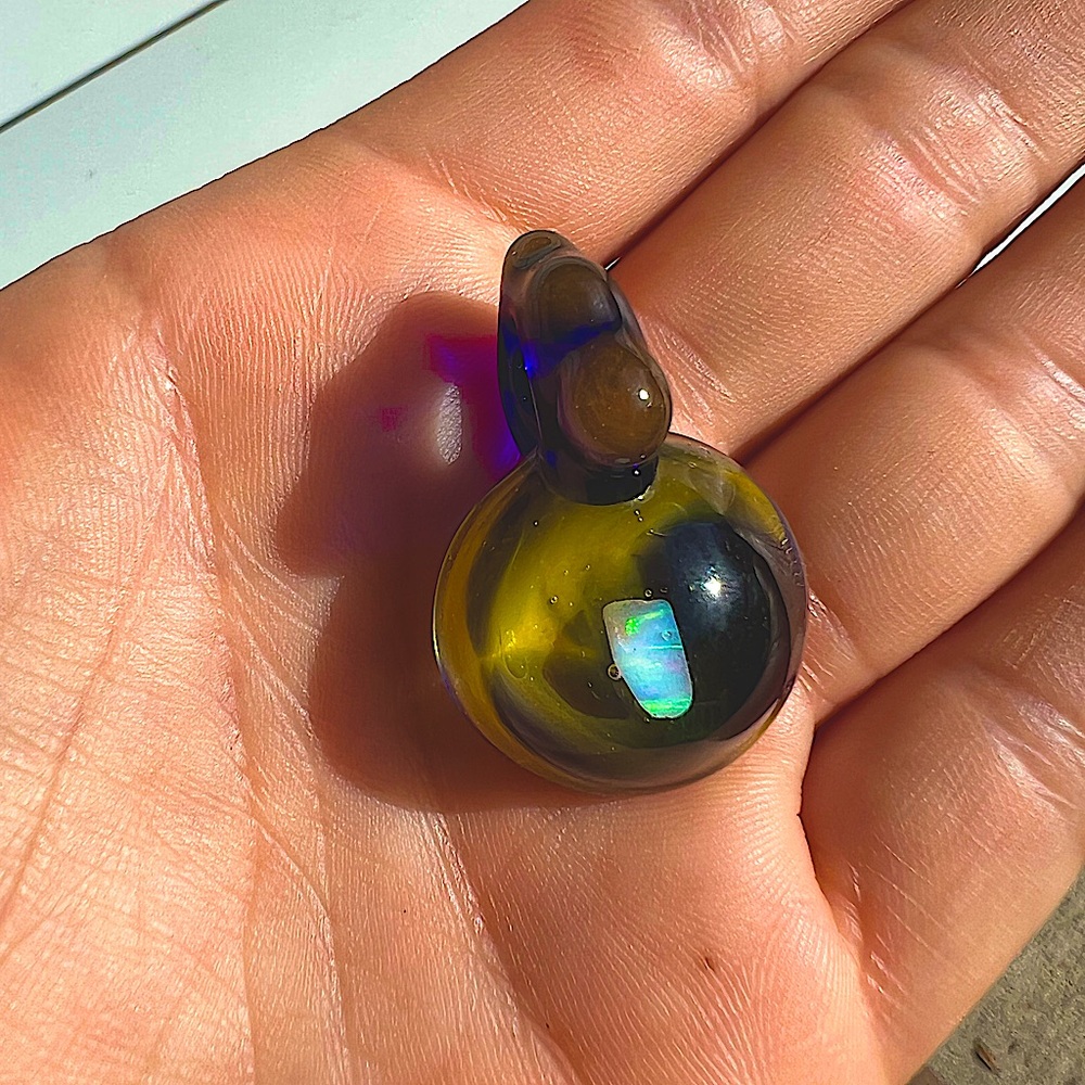 Glass blown pendant with a raw opal in the center.